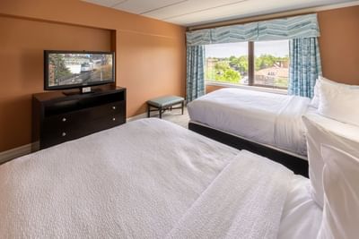 TV facing two beds by the window in the room at The Boulevard Inn & Bistro