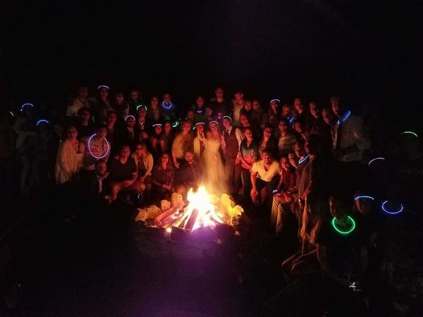 Group gathered around a lit firepit.