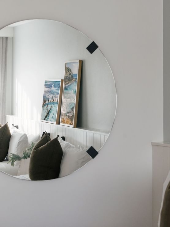 Ocean View Terrace Twin at Elysium Manly, capturing a bed with green pillows and two coastal prints on a white paneled wall