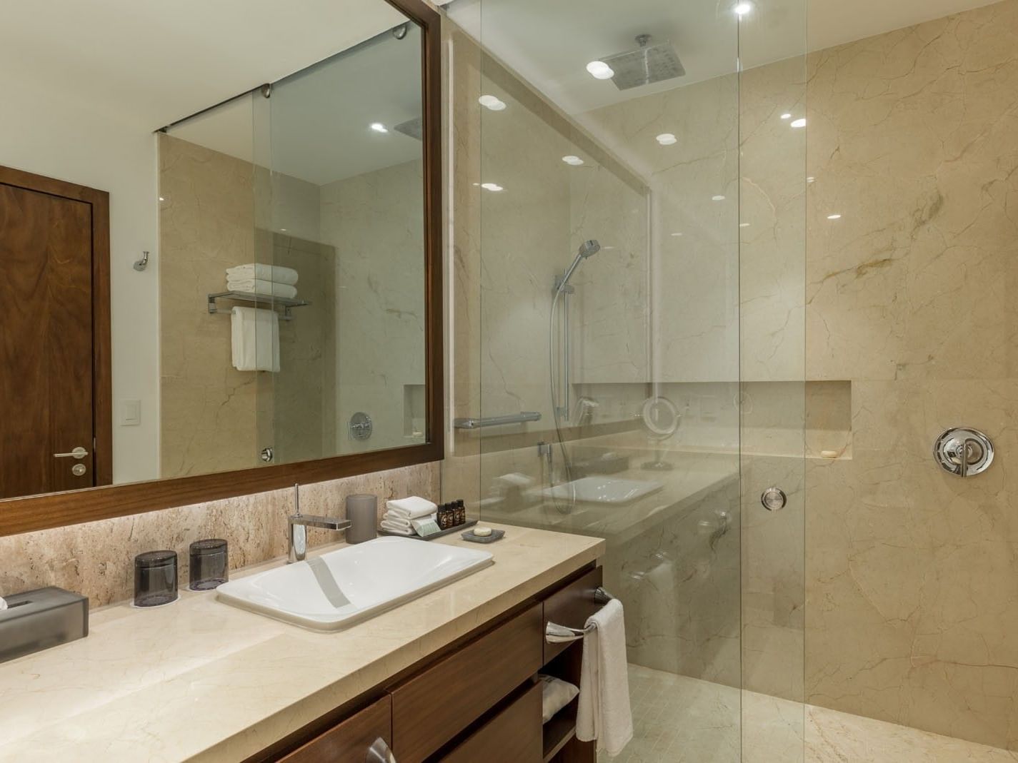 King Deluxe Bed marble bathroom with a glass walk-in shower and modern vanity lighting at Camino Real Merida