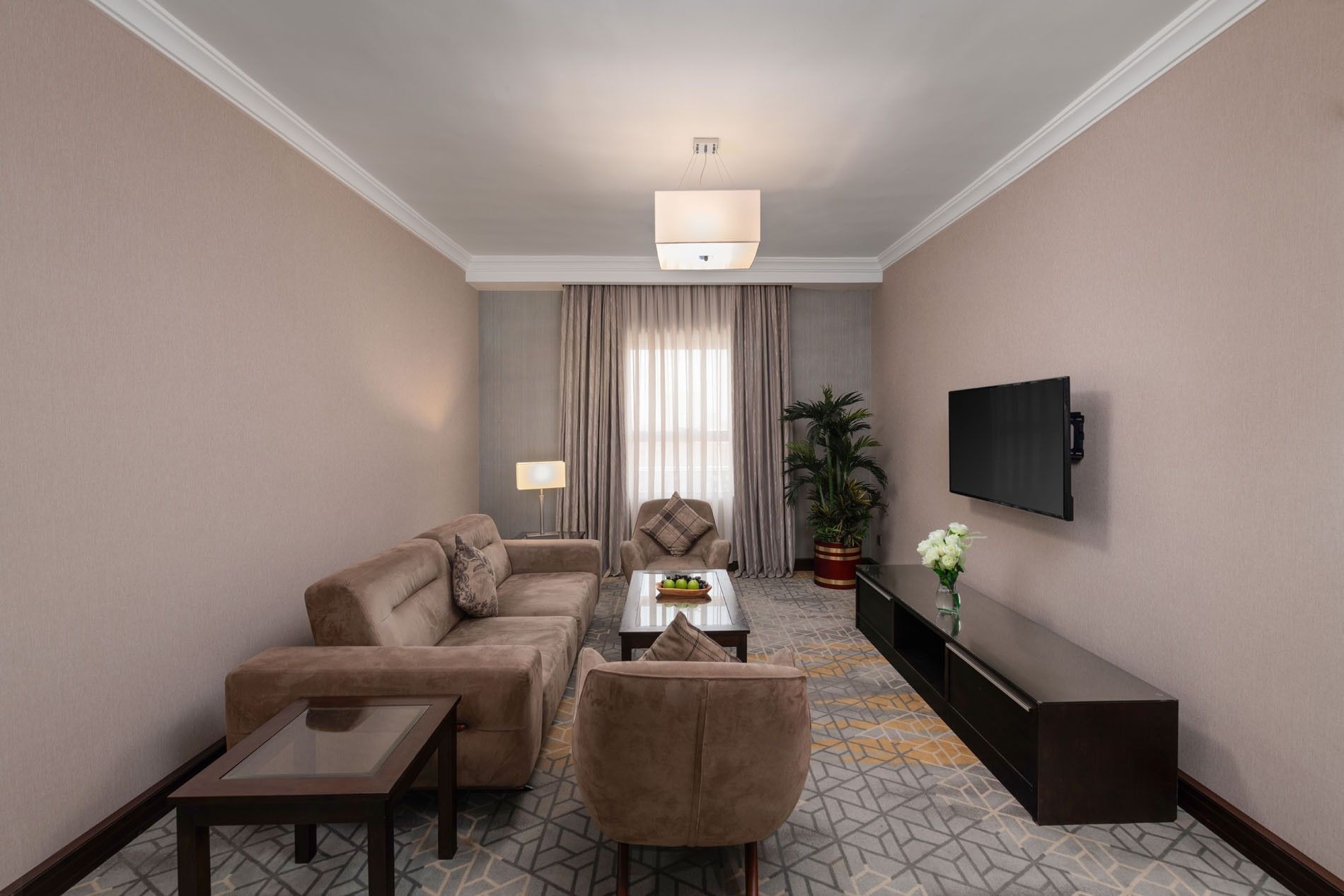 TV lounge area with plush seating and carpeted floors in Executive Two-Bedroom Suite at Warwick Hotel Jeddah