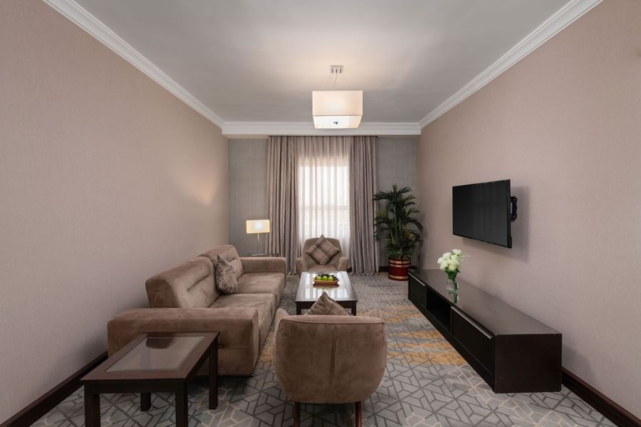 TV lounge area with plush seating and carpeted floors in Executive One-Bedroom Suite at Warwick Hotel Jeddah