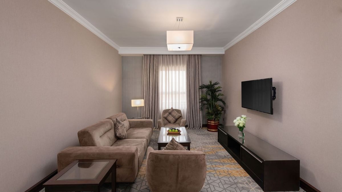 TV lounge area with plush seating and carpeted floors in Executive Two-Bedroom Suite at Warwick Hotel Jeddah