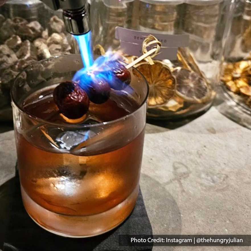 A glass of whiskey and a stick of cherry - Lexis Suites Penang