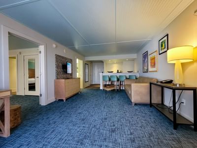 King Corner Suite featuring blue carpet, a tan sofa, and a kitchen bar at Margaritaville Resort Biloxi