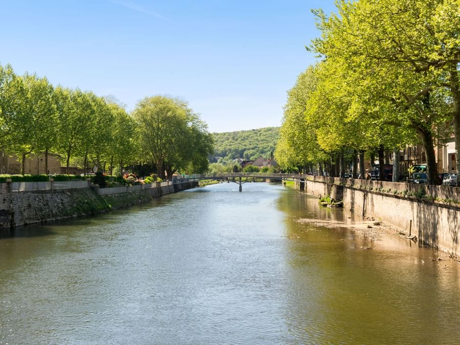 View of a river surrounded by trees near Hotel Figeac
