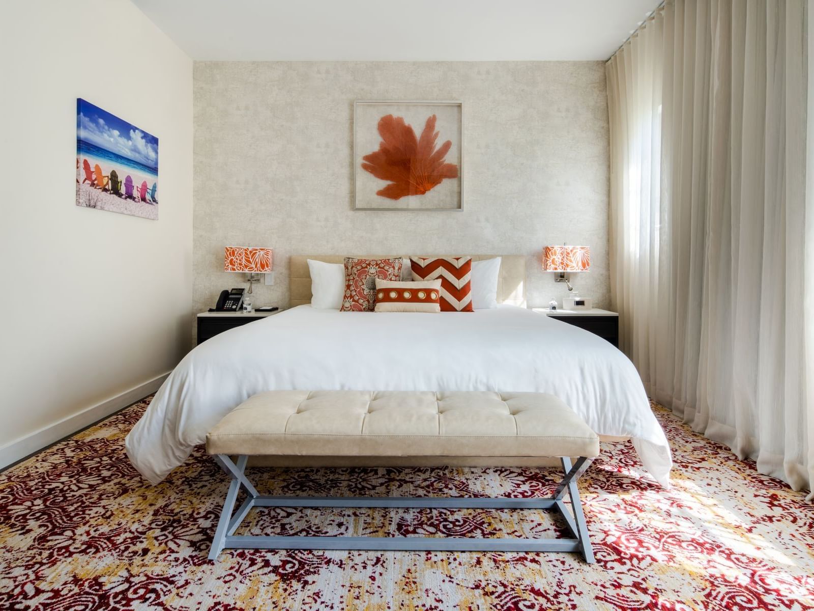large bed in carpeted room with wall art