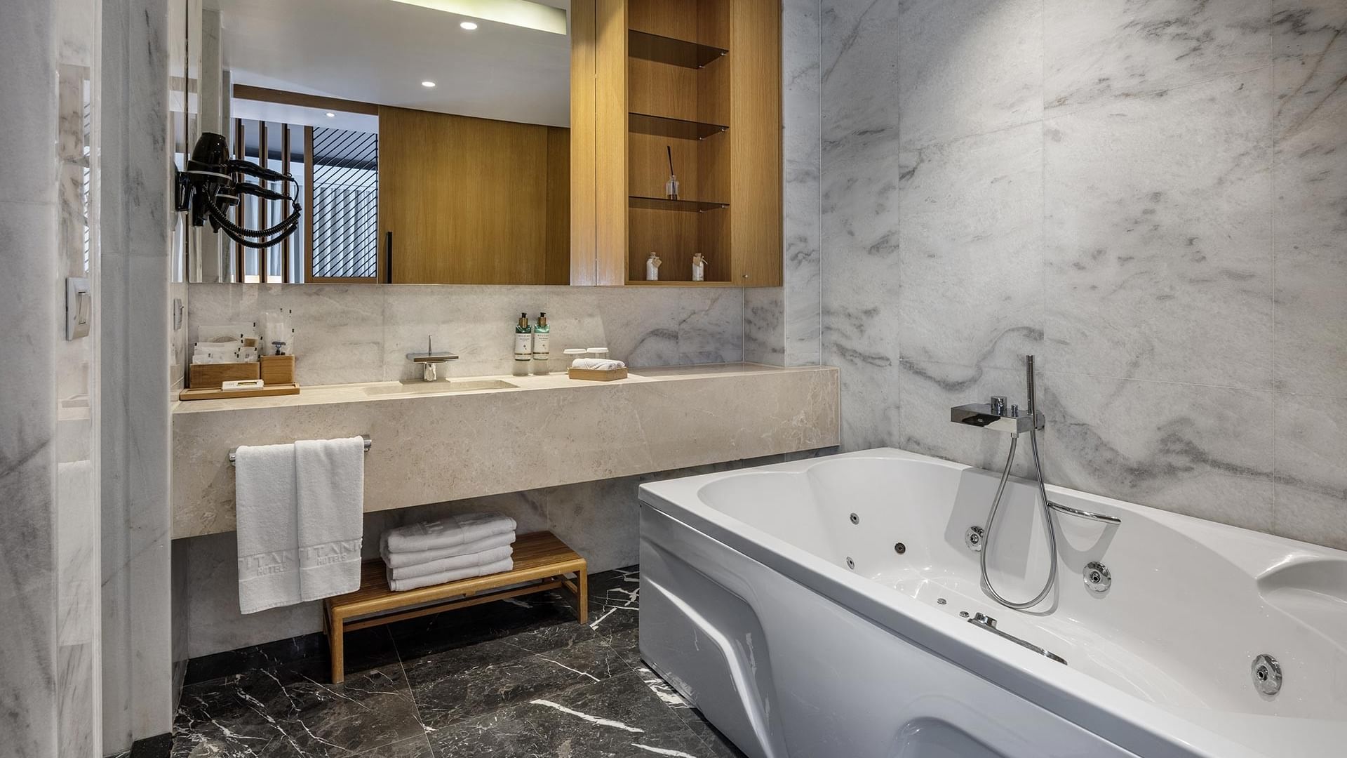 Ванная комната виллы Superior в Titanic Luxury Collection Bodrum с просторной ванной, двумя раковинами, мраморной столешницей и большим зеркалом.