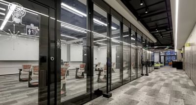 Office corridor with glass meeting rooms and sleek furniture in Rooms E F G & H, hotels in Santiago Chile at Hotel Nodo