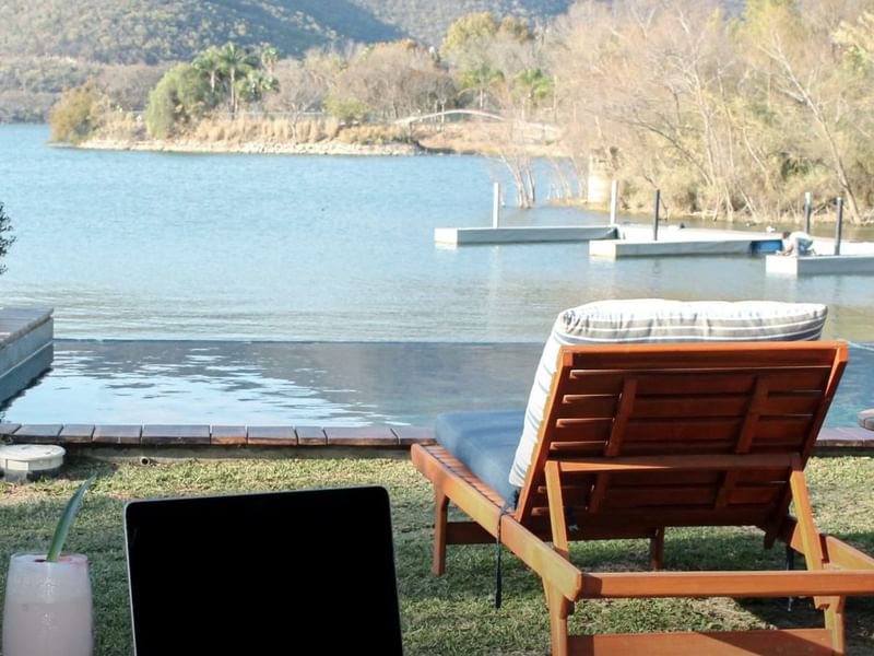 Close-up of a sunbed and a Lake view with pool at Gamma Hotels