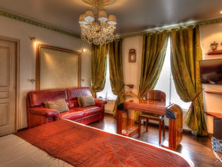 Chambre junior suite luxueuse avec canapé rouge et lustre à Hôtel Villa Aultia à Ault.