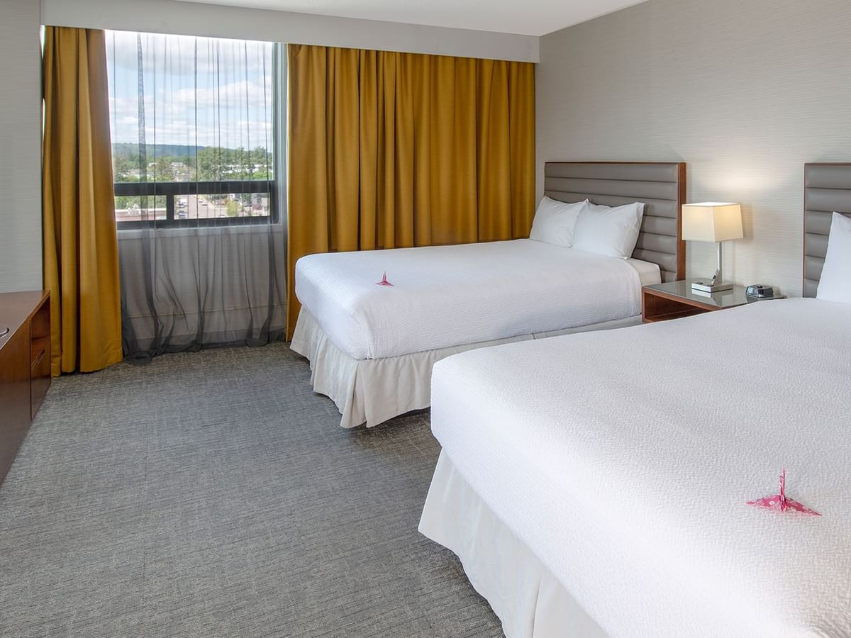 Two queen beds in a hotel suite.