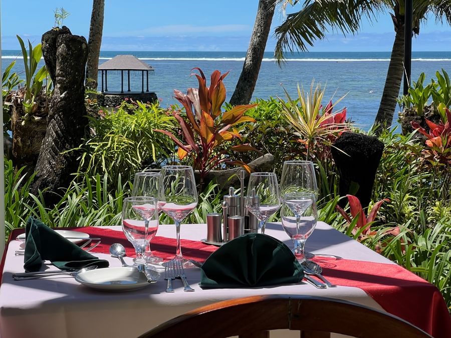 Elegantly set outdoor dining table with ocean view at Warwick Fiji Resort and Spa.