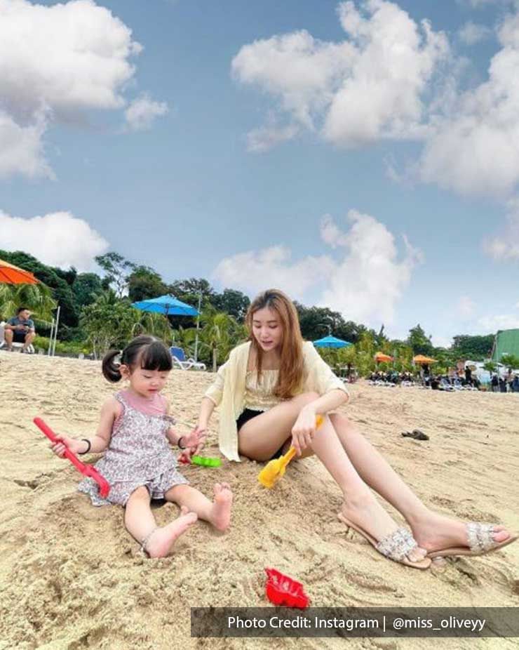 Mother and daughter playing with toys on beach - Lexis Hibiscus