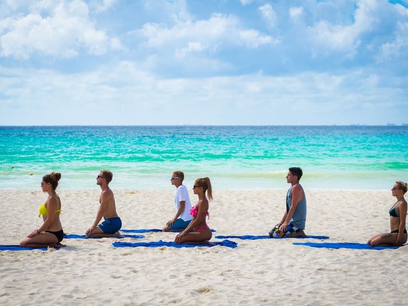Grupo de personas haciendo Yoga en la Playa de The Reef Playacar en Playa del Carmen