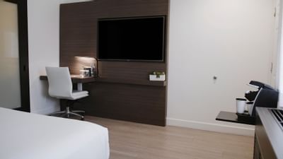 Wall-mounted TV & working desk in a room at The Nest