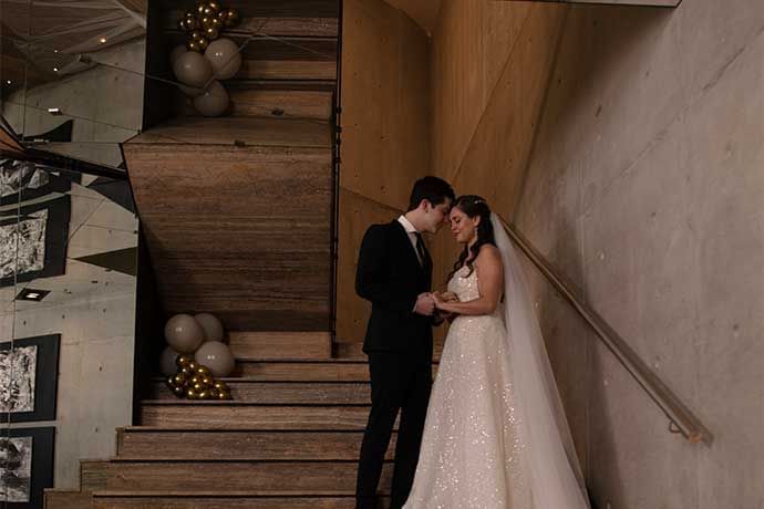 Wedded couple holding both hands on stair at Live Aqua Resorts and Residence Club