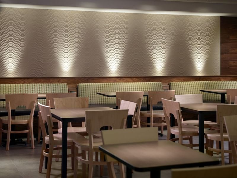 Mesas de comedor marrones en la sala de desayunos de One Hotels