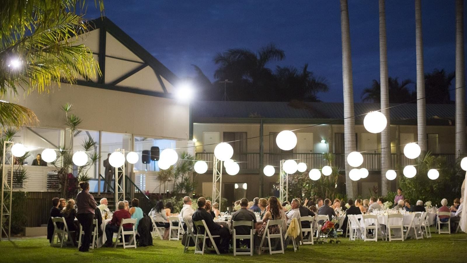 Well-lit outdoor venue with round tables and hanging lanterns at Mercure Hotel Townsville