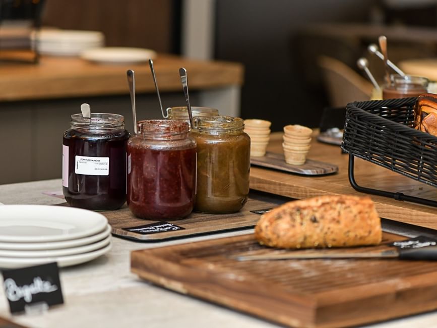 Pain frais et confitures variées sur une table élégante chez Hôtel Rivella.