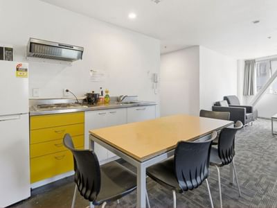 A dining area with a table and chairs in a living space at Student Living Auckland Anzac.