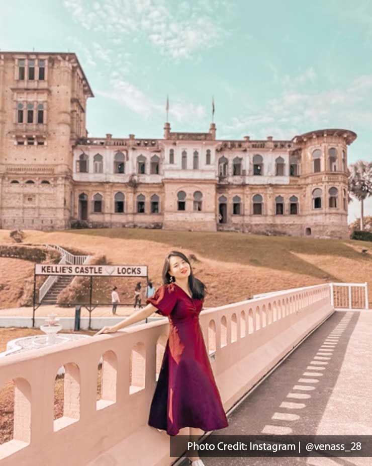 A woman was taking a picture with the Kellie’s Castle - Lexis Suites Penang