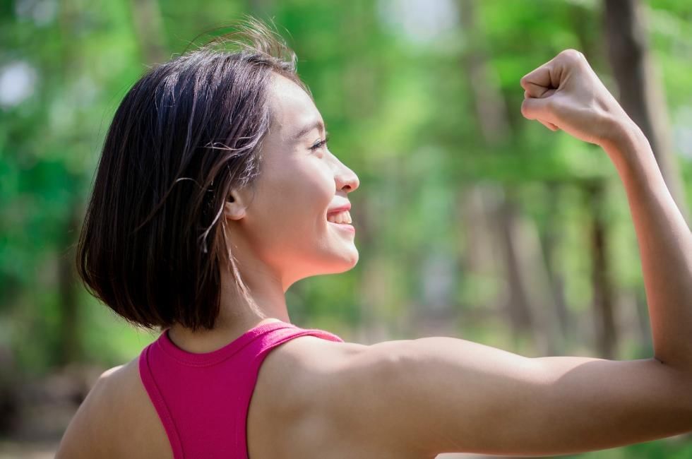 Women showing of her flex muscles after strongman workout