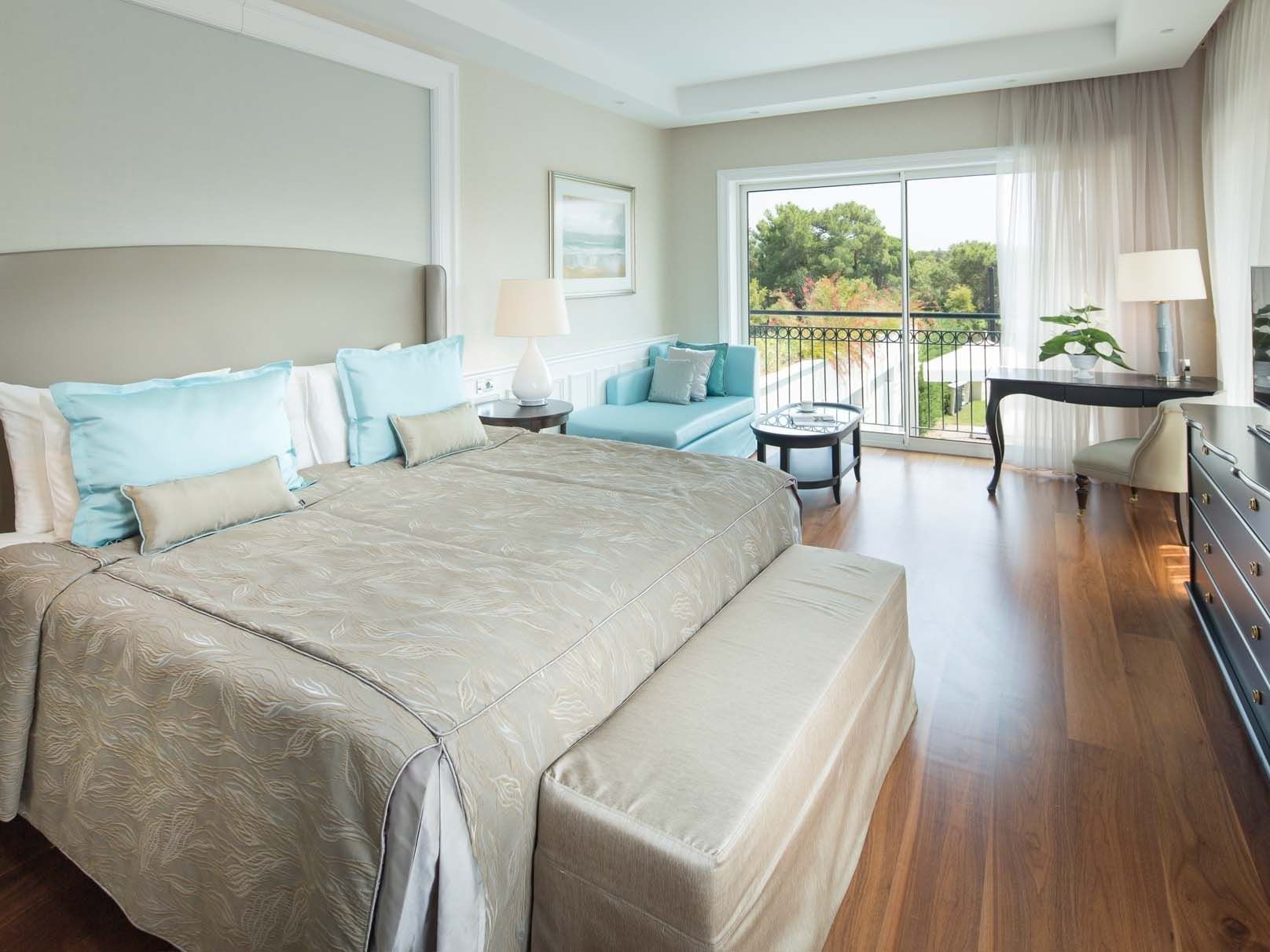 Sitting area by the bed in Design Pool Villa with wooden floors at Titanic Deluxe Golf Belek