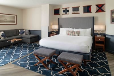 Cozy bed with sitting area in Junior Suite at Portland Harbor Hotel