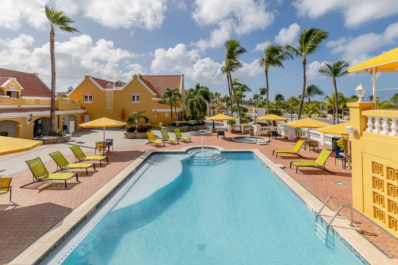 Outdoor pool area with lounge chairs at Amsterdam Manor Beach Resort Aruba