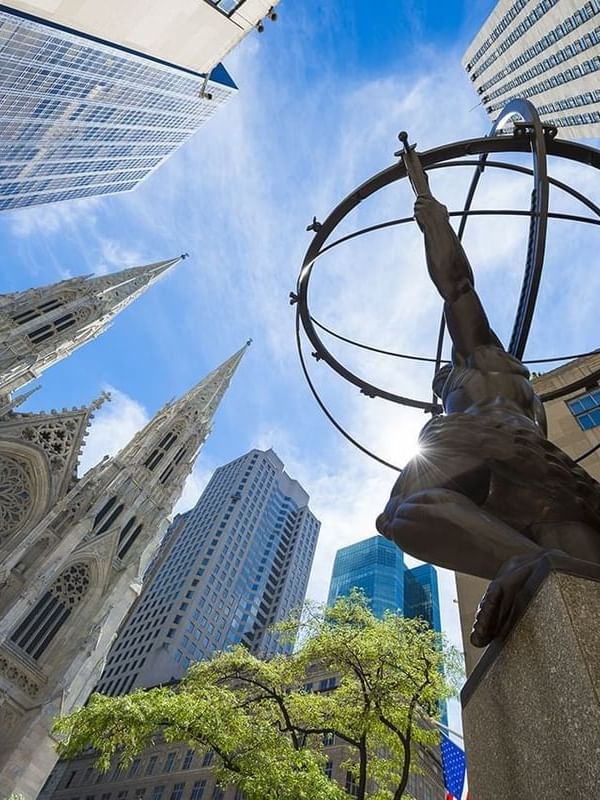 Low-angle view of ATLAS statue with buildings near Warwick New York