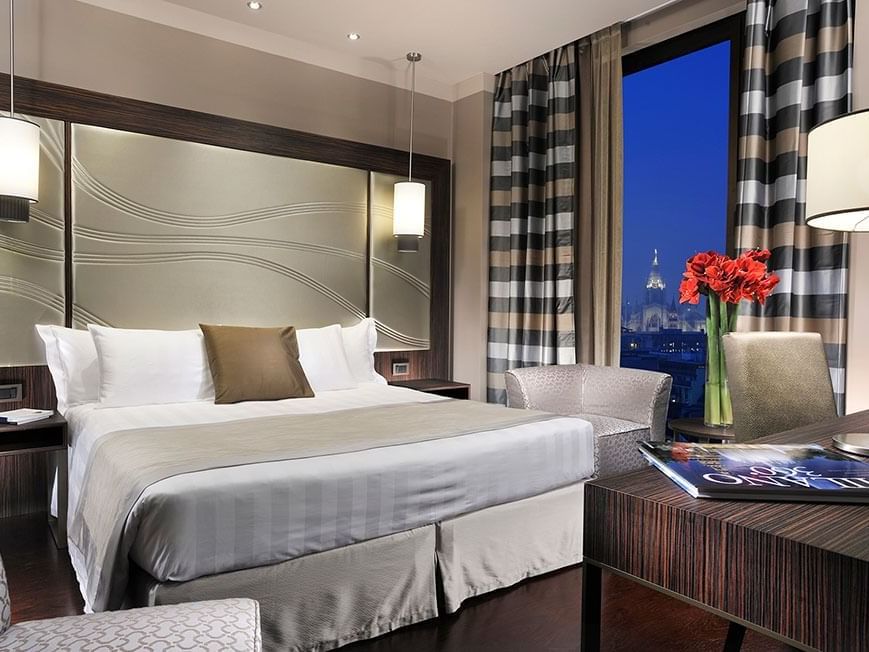 Bed & furniture in Deluxe King Room at Uptown Palace in Milan