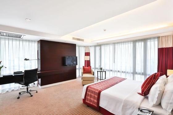 Bedroom with working desk in Suite at Eastin Hotels