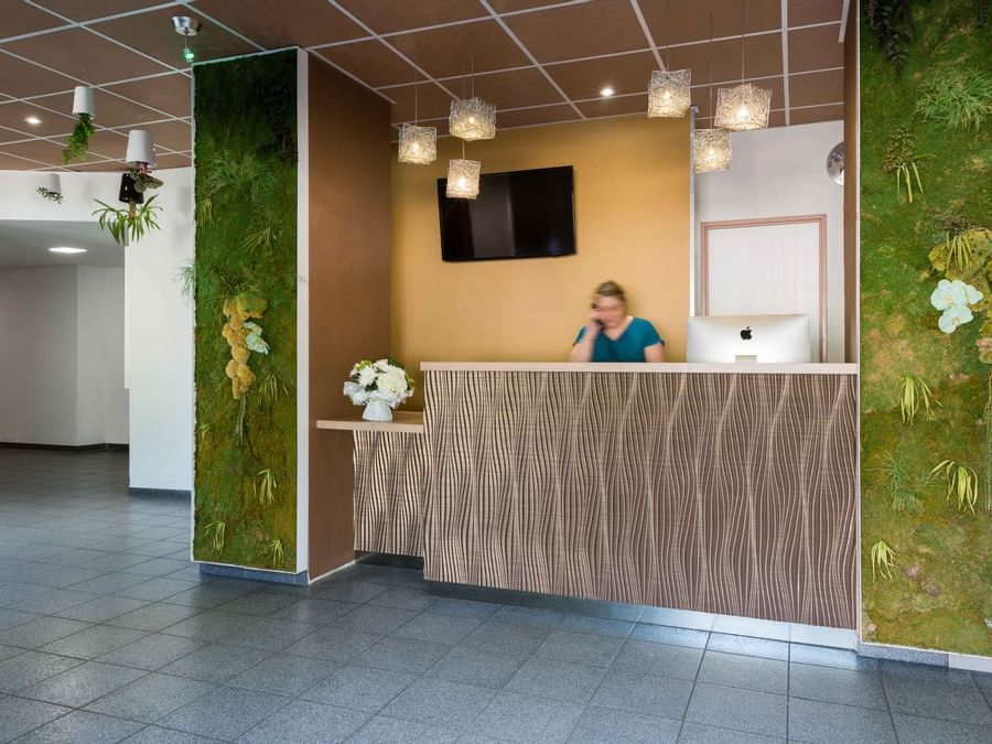 A receptionist at the reception desk in Archotel