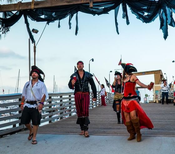 People in pirate costumes walking on a pier near Catalina Island Company, one of the things to do in catalina island