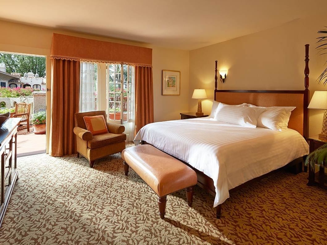 room with king bed, door to exterior and accent chair