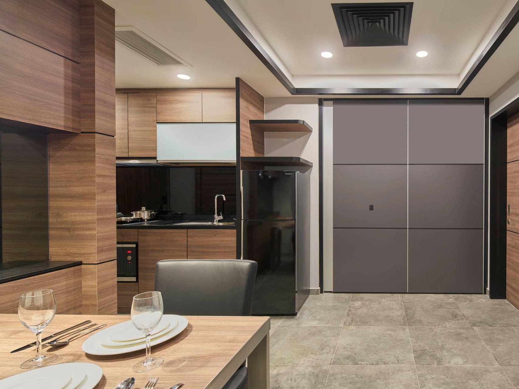 Image 43: Chic One Bedroom kitchen with wood cabinets, black counters, and a modern dining setup for two at Orchard Grand Court