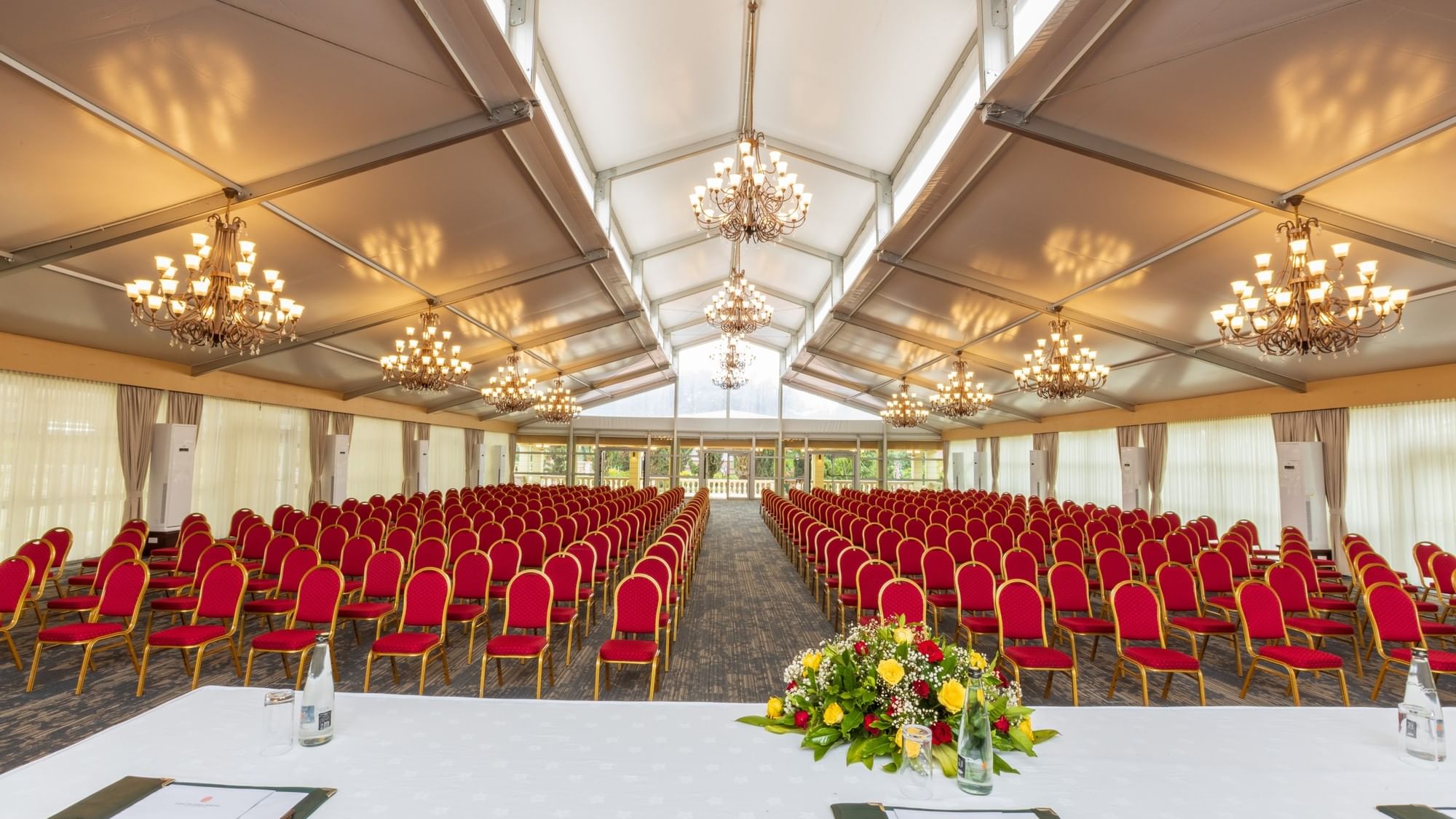 Kalangala Hall with chairs, chandeliers, and a flower arrangement at Lake Victoria Serena Golf Resort & Spa, Kampala.