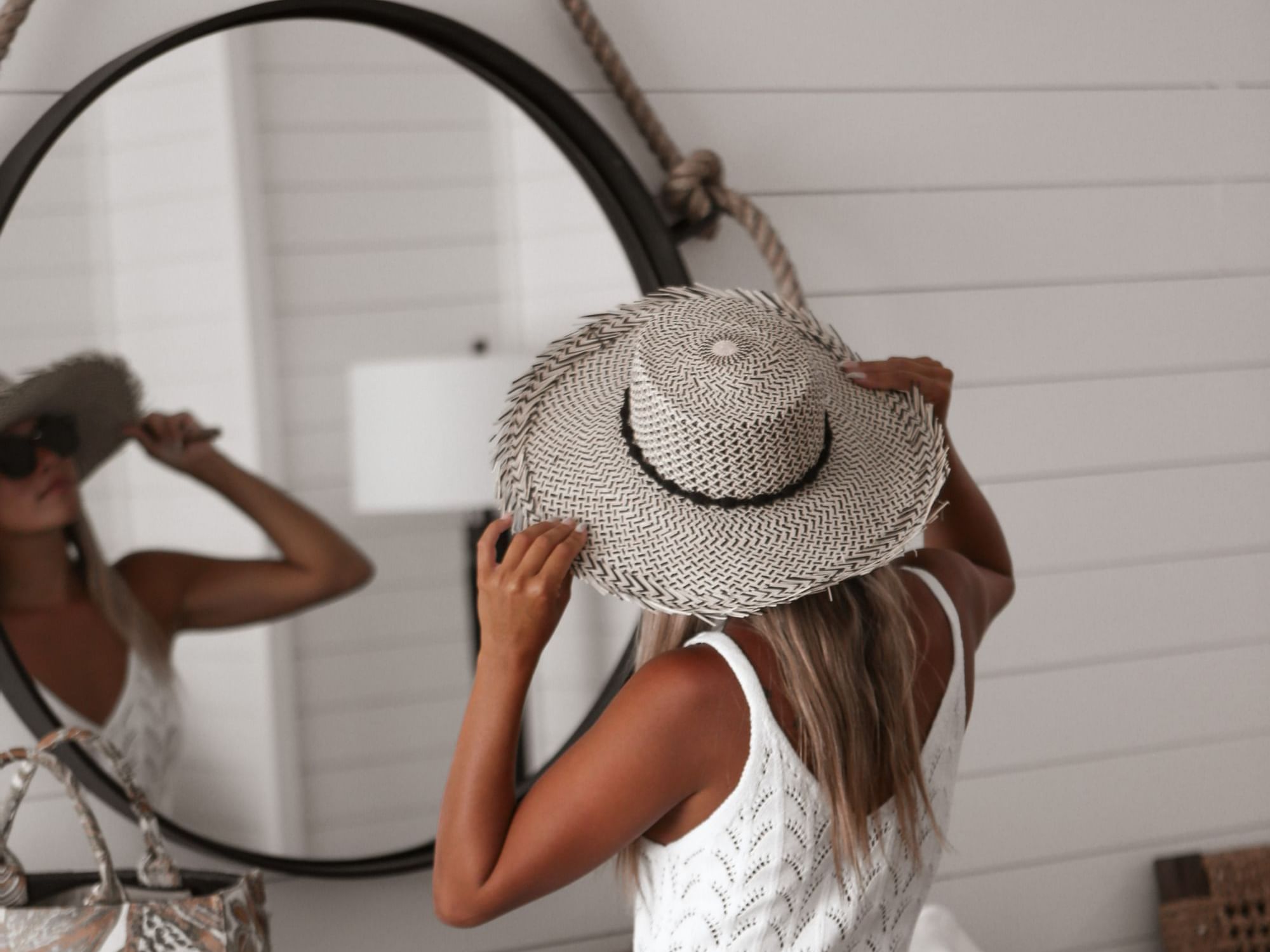 A lady with hat looking in mirror at Boulan South Beach Hotel