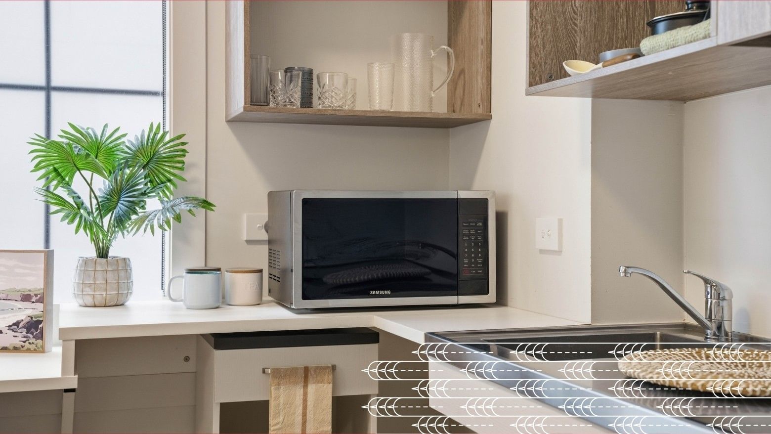 Modern kitchen area with microwave, sink, and decor at Mayoral Drive Student Accommodation.