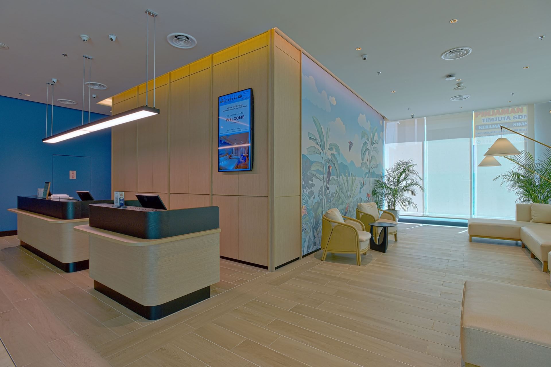 Reception desk by lobby lounge with plush seating & potted plants at Cititel Express Kota Kinabalu