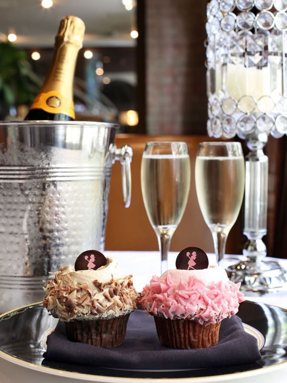 Champagne, cupcakes, and a candle on a table for the Birthday Wishes Package.