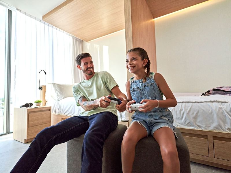 Father & daughter playing video games at IOH Freestyle Hotels