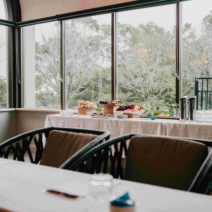 Mercure Charlestown room with large windows and a table set for dining.