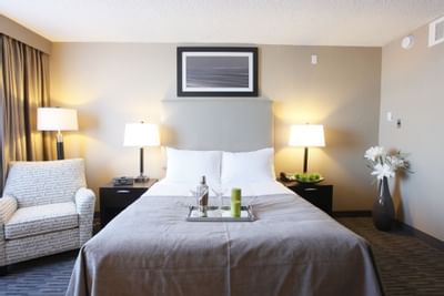 a tray of mixed drinks on a bed in a hotel room