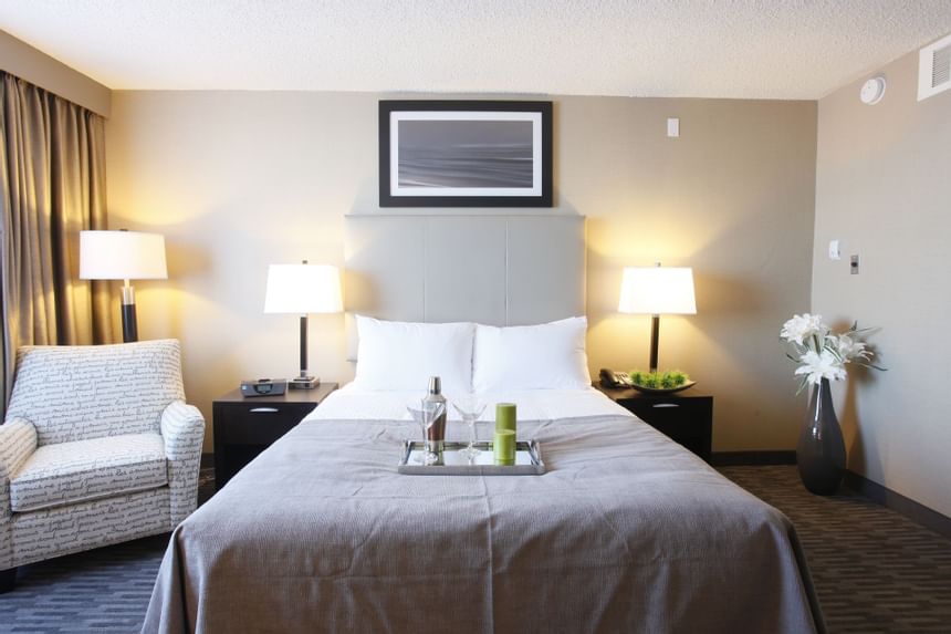 a tray of mixed drinks on a bed in a hotel room