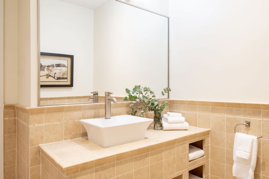 Bathroom vanity, mirror & towels in a residence at Retro Suites Hotel