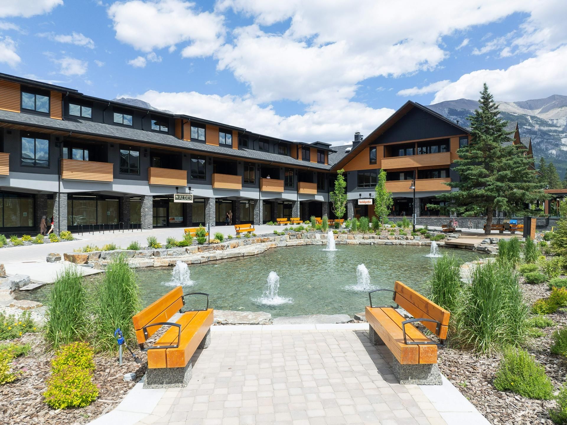 Exterior of Spring Creek Vacations with a fountain and benches with mountain backdrop