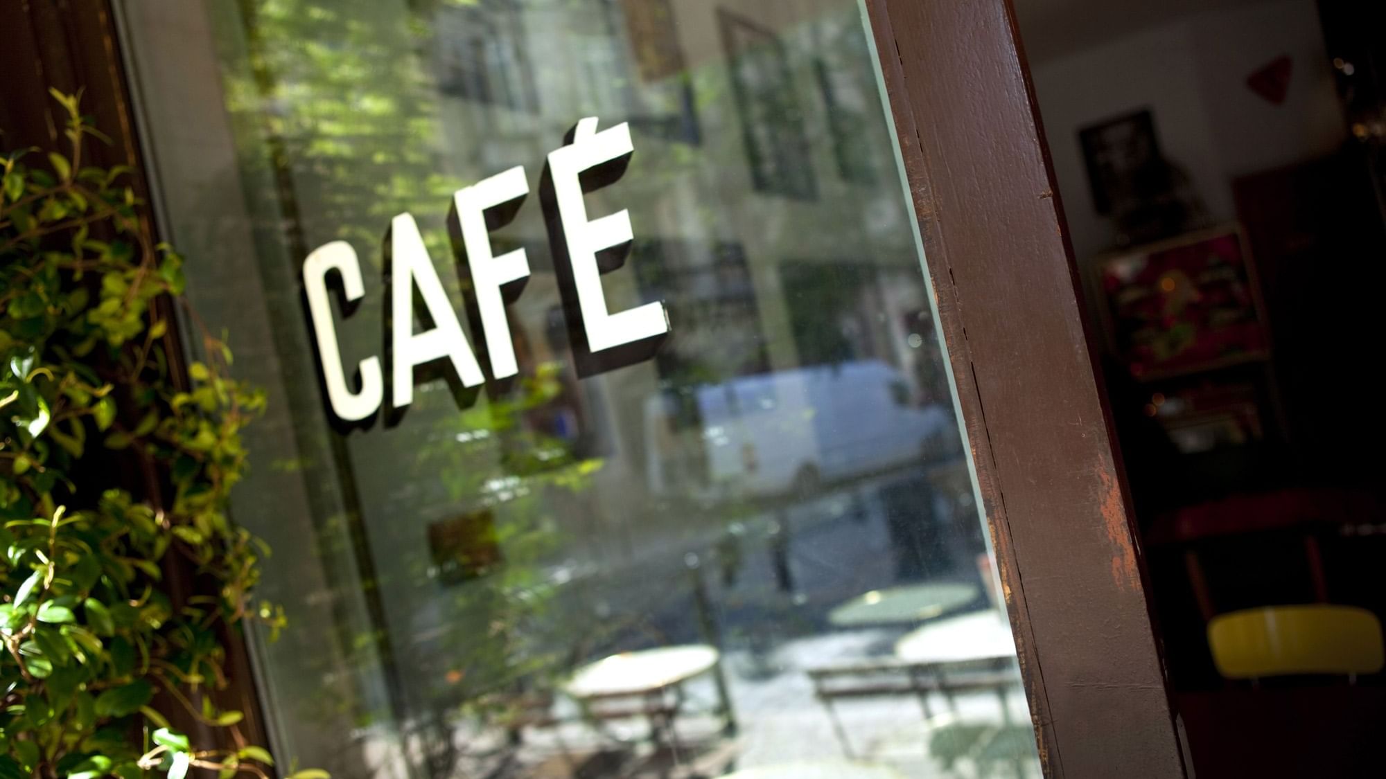 Closeup of the Cafe sign on a glass door near Originals Hotels