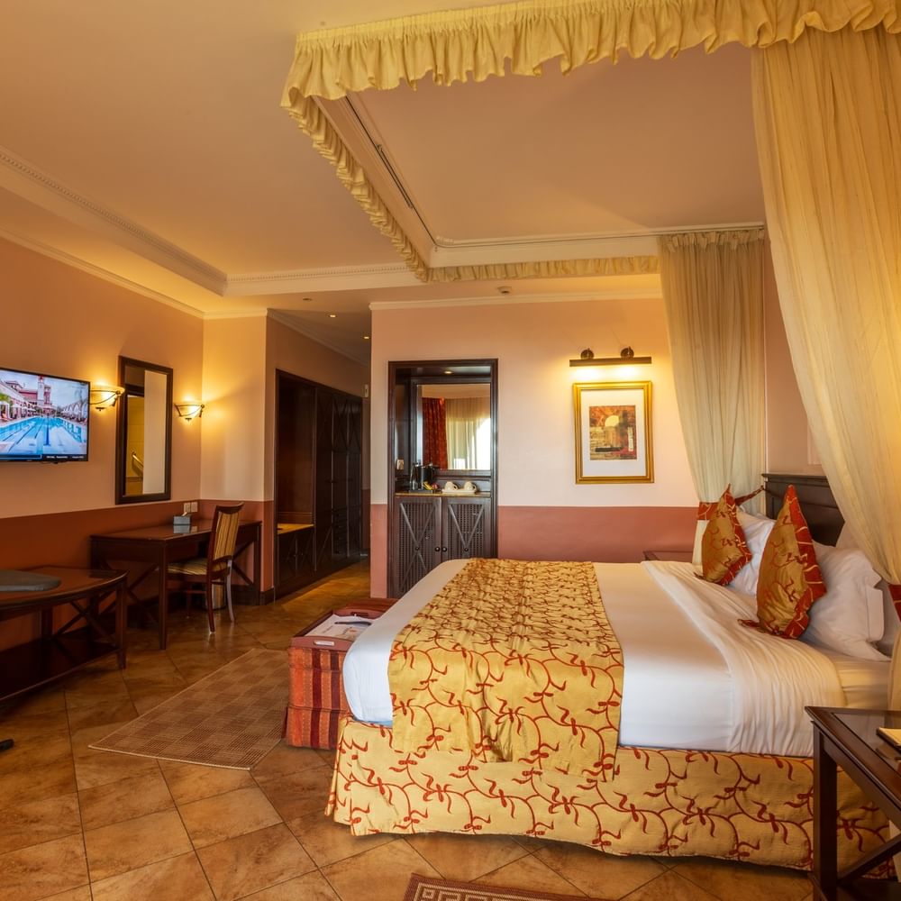 Elegant Standard Deluxe Room with a king-sized bed, draped canopy, and modern amenities at Lake Victoria Serena Golf Resort & Spa in Kampala.